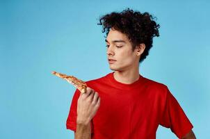 gars où est il et cheveux dans une rouge T-shirt avec une tranche de Pizza sur une bleu Contexte photo