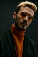 élégant homme avec des lunettes Orange chandail manteau noir Contexte photo