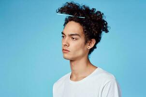 homme avec peigne coincé dans frisé cheveux fermer portrait et blanc T-shirt photo