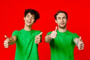 de bonne humeur copains dans vert t-shirts faire des gestes avec mains émotions rouge Contexte photo