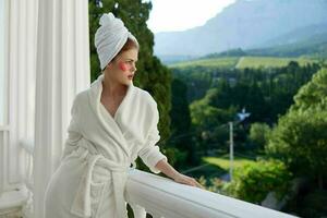 femme dans une peignoir de bain profiter sa Matin à le balcon mode de vie photo