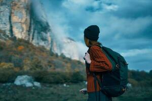 voyageur dans une chandail avec une sac à dos sur sa retour tourisme des nuages ciel paysage photo