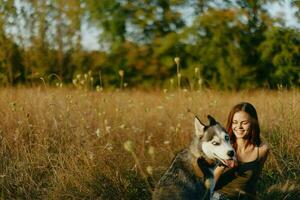 femme séance dans champ avec teckel chien souriant tandis que dépenses temps en plein air avec chien ami photo