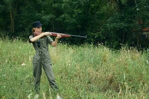 femme soldat il est en portant une pistolet dans une vert chasse salopette Frais air photo