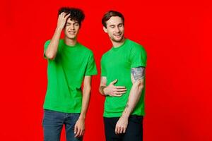 de bonne humeur copains dans vert t-shirts la communication émotions isolé Contexte photo