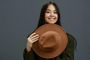 magnifique femme dans une costume avec une chapeau posant décontractée porter gris Contexte photo