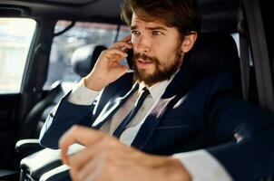 les hommes d'affaires conduite une voiture voyage luxe mode de vie la communication par téléphone photo