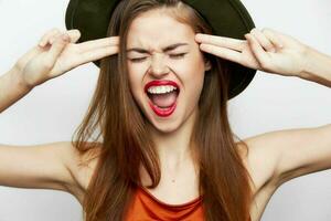 femme dans une vert chapeau avec le sien bouche ouvrir, il détient le sien doigt à le temple sexy Regardez photo