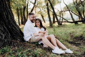 jeune couple amoureux un mec avec une barbe et une fille aux cheveux noirs dans des vêtements clairs photo