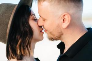 jeune couple un mec avec une fille en vêtements noirs marchent sur le sable blanc photo