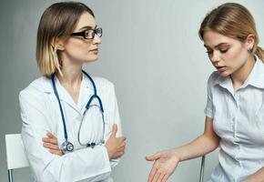 une patient est assis sur une chaise et une femme médecin avec une stéthoscope photo