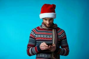 de bonne humeur homme avec une téléphone dans main vacances Noël La technologie bleu Contexte photo