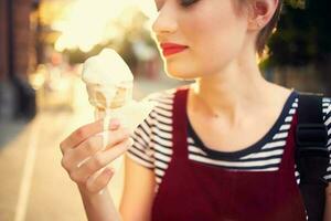 femme avec court cheveux sur le rue avec la glace crème dans sa mains amusement photo