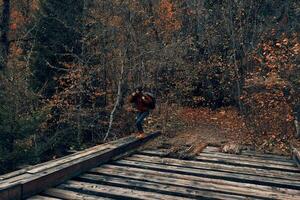 femme touristique des croix le pont plus de le rivière Voyage dans l'automne photo