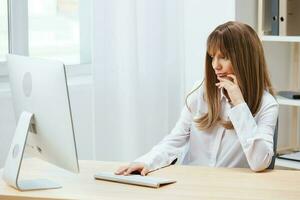 concentré adorable blond femme d'affaires ouvrier pigiste Regardez à écran en pensant de problème Solution dans lumière moderne bureau. employé travail sur ordinateur en ligne méditer fabrication décision. copie espace photo