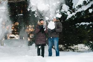 garçon et fille à l'extérieur sur une promenade hivernale jouant des boules de neige photo