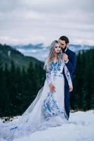 Marié dans un costume bleu et mariée en blanc dans les montagnes des Carpates photo