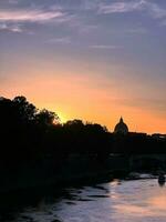 le coucher du soleil plus de le Tibre dans Rome, avec une vue de le coupole photo