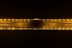 brillant lumières, des ponts avec arcs, nuit ville. une route pont à travers le rivière, pris de une drone. photo