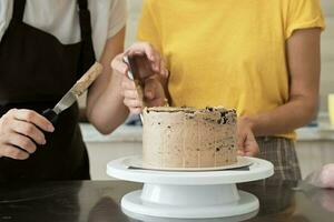 femmes couple fabrication Chocolat gâteau dans cuisine, fermer. gâteau fabrication processus, sélectif concentrer photo