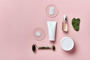 cosmétique beauté des produits et pierre masseurs sur rose Contexte. visage massage soin de la peau concept photo