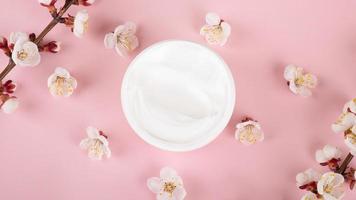 crème et fleurs sur fond rose, cosmétique de soins de la peau beauté photo