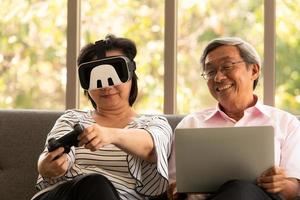 Senior homme asiatique et femme se détendre en vacances dans le fond de salon naturel avec la technologie moderne photo