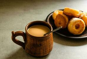 le plus délicieux fait maison beignets et café avec Lait dans une populaire tasse. Accueil cuisson. photo