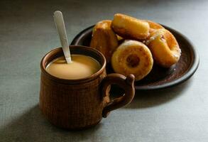 le plus délicieux fait maison beignets et café avec Lait dans une populaire tasse. Accueil cuisson. photo