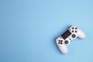 Contrôleur de jeu joystick isolé sur fond bleu, console de jeux vidéo a développé un divertissement interactif