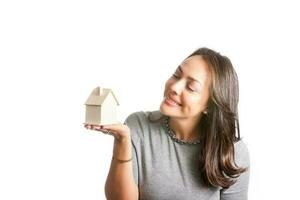 Jeune magnifique femme rêver avec une Nouveau maison isolé sur blanc Contexte photo