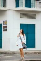 magnifique femme sur blanc robe en marchant seul à le des rues de le colonial fortifiée ville de Carthagène de Indes photo