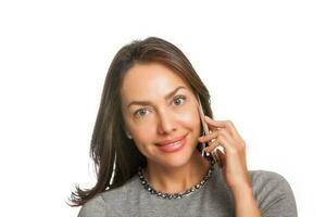 Jeune femme souriant et parlant sur sa téléphone portable isolé sur blanc Contexte photo