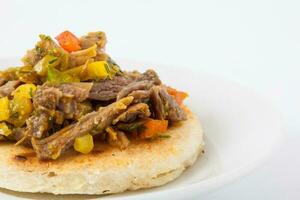 traditionnel colombien arepa surmonté avec déchiqueté du boeuf photo