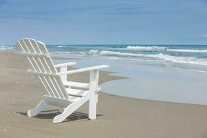 vide blanc en bois chaise à une paradisiaque plage sur le tropiques dans une magnifique ensoleillé journée photo