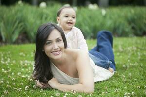 bébé fille en jouant avec sa maman sur le herbe photo