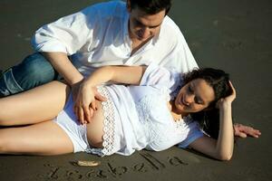 couple à le plage attendre pour leur bébé - 28 semaines photo