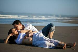 couple à le plage attendre pour leur bébé - 28 semaines photo