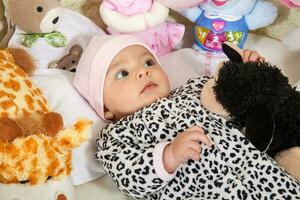 quatre mois bébé fille entouré par farci animaux photo