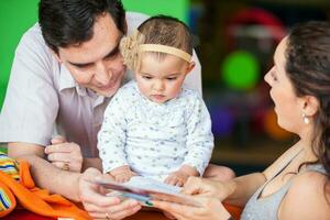 Jeune Parents en jouant avec leur neuf mois bébé fille. bonheur concept. apprentissage et éducation concept photo