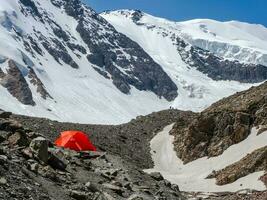 Orange tente sur une glacier. extrême pendant la nuit rester dans le montagnes. photo