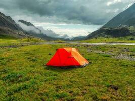 camping sur une été vert haute altitude plateau. Orange tente après le pluie. paix et relaxation dans la nature. photo