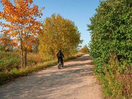 village motard course le long de une poussiéreux pays route. photo