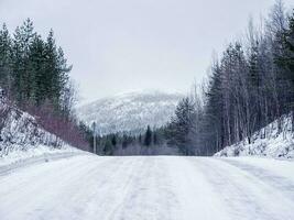 vide le glissant hiver route, une raide montée en haut le colline. photo