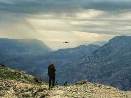 drone photographe départ une dron dans mal temps sur une falaise dans le montagnes. photo