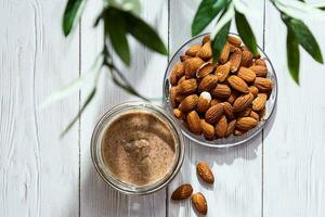 pot de amande beurre avec amandes tas. fait maison amande beurre, naturel, en bonne santé aliments. photo