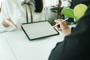 homme d'affaire travail en équipe réunion et discuter sur avec maquette tablette en utilisant style stylo. photo