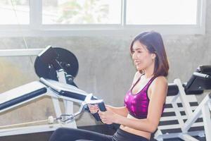 belle femme asiatique exerçant dans la salle de gym photo