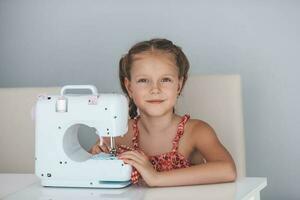 sept ans vieux enfant en train d'étudier travail avec une moderne couture machine. passe-temps. photo