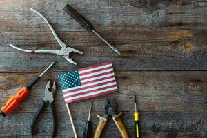 content la main d'oeuvre journée. construction outils et le Etats-Unis Amérique drapeau . copie espace pour texte sur bois Contexte. photo